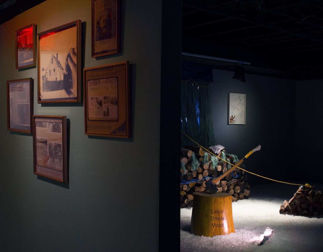 The installation: framed photographs, the chopping block and salt floor