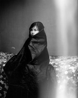 A child wrapped in a dark blanket