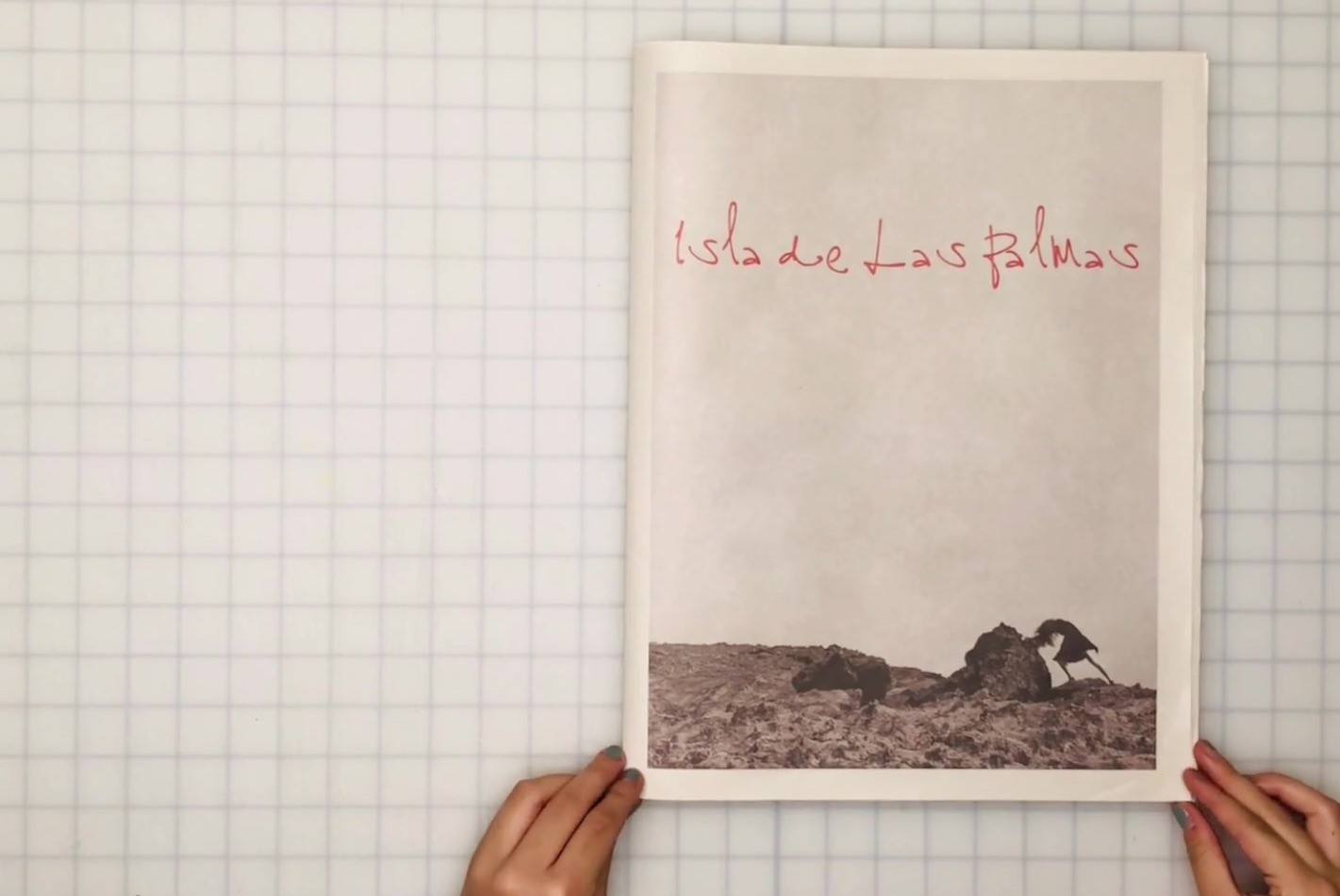 The newsprint book of Isla de Las Palmas, held open to its cover